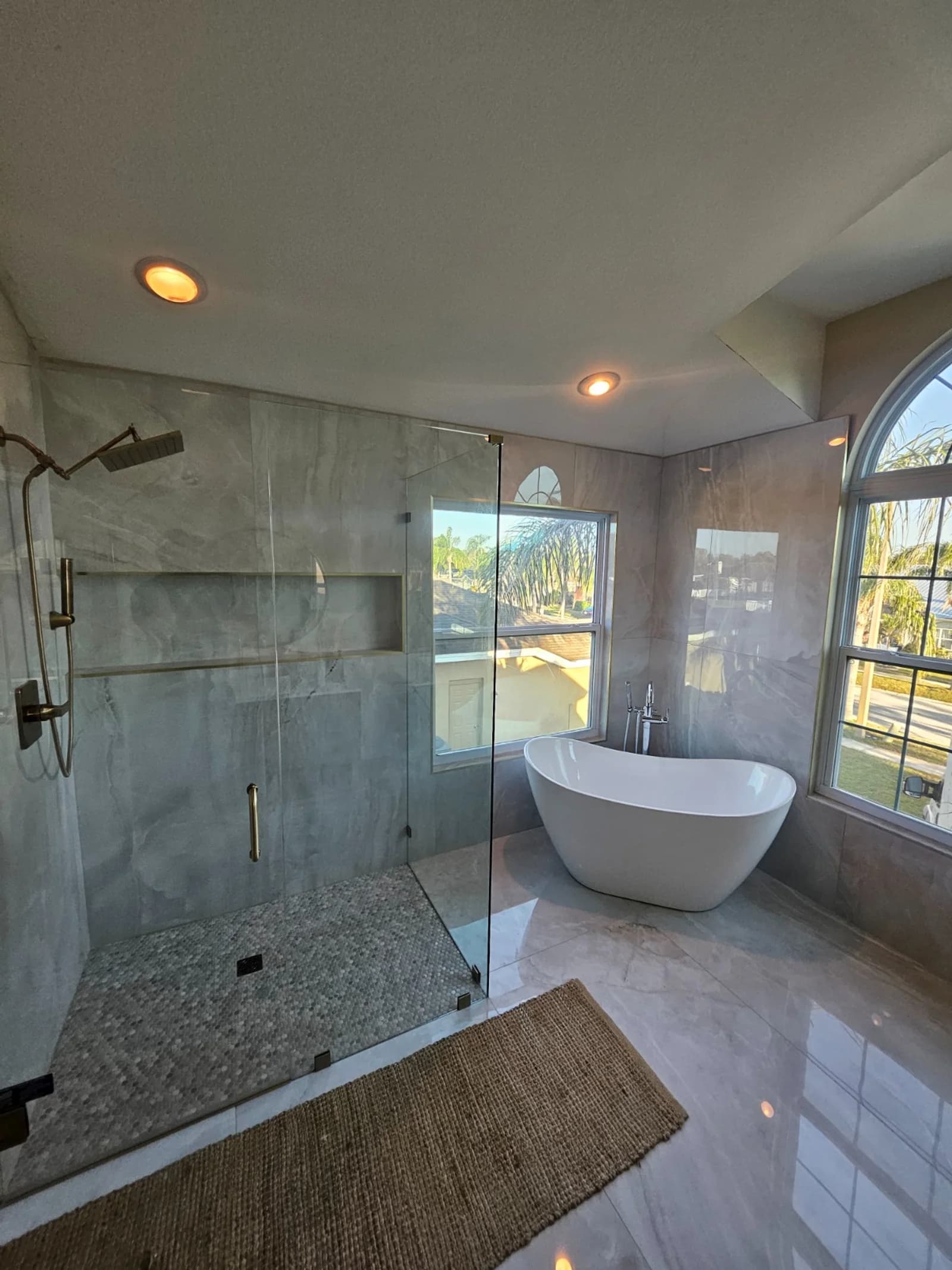 Master bathroom with arched window and freestanding tub