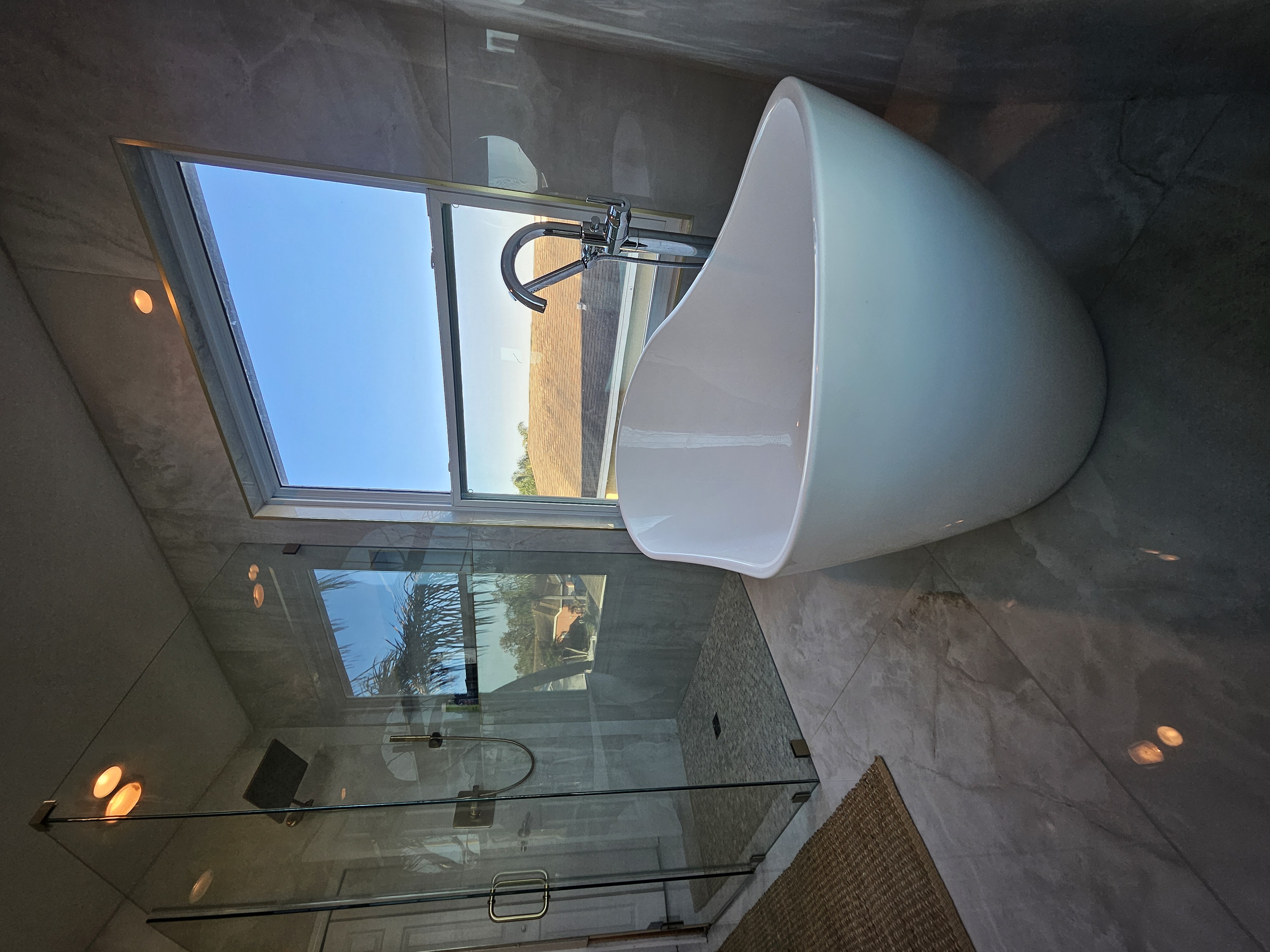 Marble bathroom remodel with soaking tub and glass shower